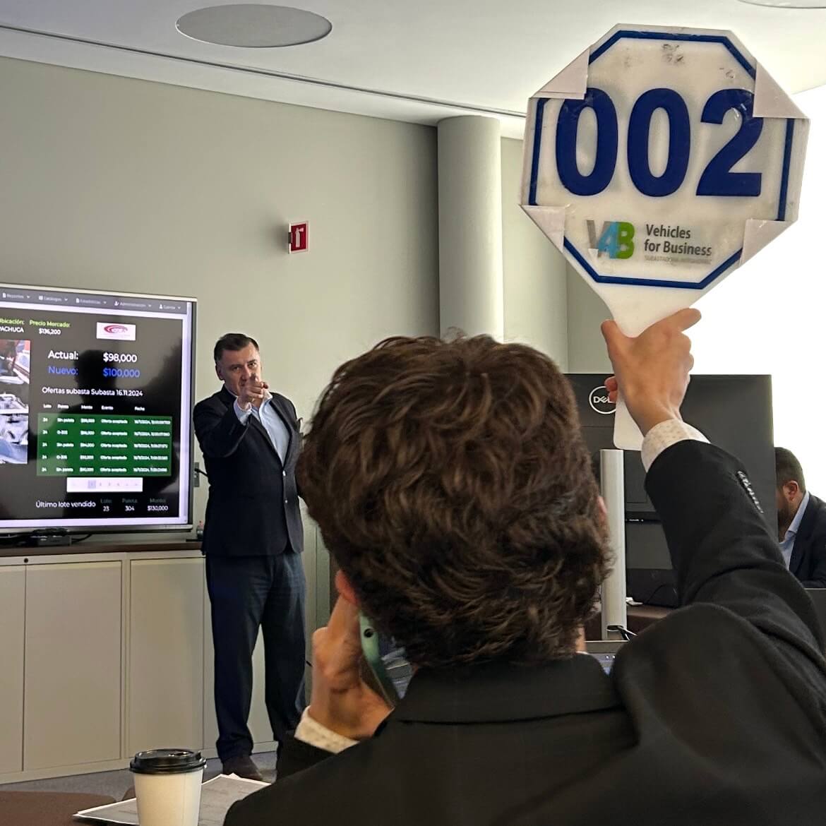 Comprador levantando paleta en subasta V4B